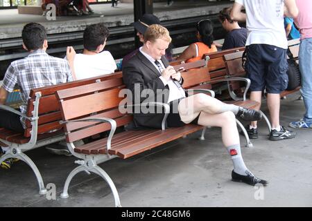 Ein Geschäftsmann wartet auf den Zug auf dem Bahnsteig am Circular Quay Bahnhof auf der Sydney No Pants Subway Ride 2014. Stockfoto