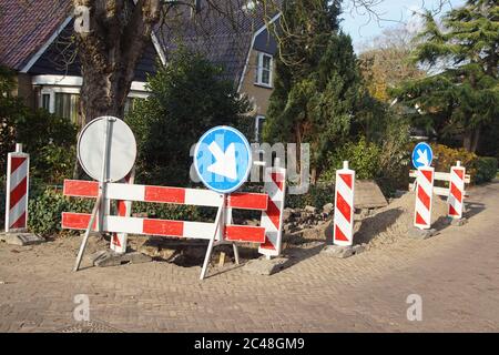 Straßenarbeiten in der Straße mit einem Loch, Pflastersteine und Straßenschilder. November, Bergen, Niederlande. Stockfoto