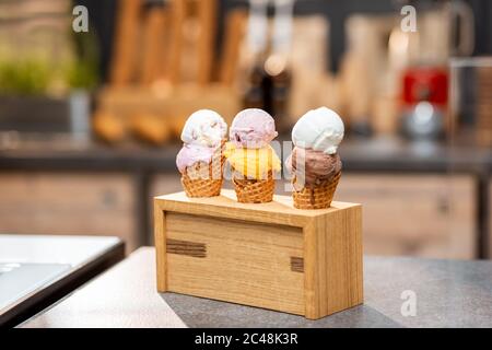 Eis in Waffelkegel mit verschiedenen Geschmacksrichtungen auf der Ladentisch, Nahaufnahme Stockfoto