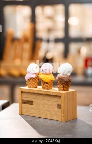 Eis in Waffelkegel mit verschiedenen Geschmacksrichtungen auf der Ladentisch, Nahaufnahme Stockfoto