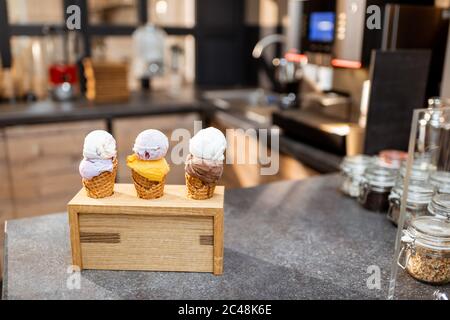 Eis in Waffelkegel mit verschiedenen Geschmacksrichtungen auf der Ladentisch, Nahaufnahme Stockfoto