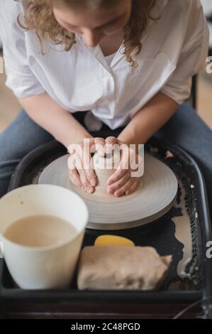 Die Hände eines Töpfers, erstellen ein irdenes Gefäß auf dem Kreis. Stockfoto