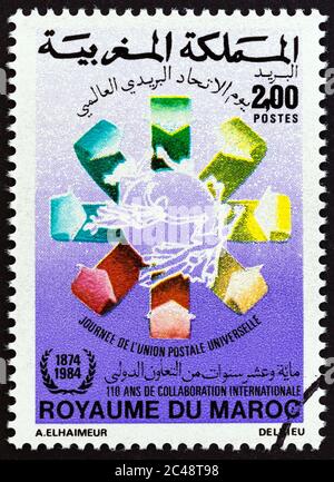 MAROKKO - UM 1984: Eine in Marokko gedruckte Briefmarke, die für den Weltpostgewerkstag ausgestellt wurde, zeigt das Emblem, um 1984. Stockfoto