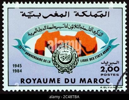 MAROKKO - UM 1984: Eine in Marokko gedruckte Briefmarke, die zum 39. Jahrestag der Arabischen Liga ausgegeben wurde, zeigt Emblem, um 1984. Stockfoto