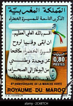 MAROKKO - UM 1984: Eine in Marokko gedruckte Briefmarke, die zum 9. Jahrestag von 'The Green March' herausgegeben wurde, zeigt die Schriftrolle, um 1984. Stockfoto