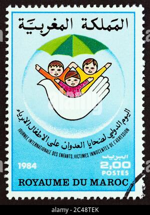 MAROKKO - UM 1984: Eine in Marokko gedruckte Briefmarke, die für den Internationalen Tag der Kinderopfer ausgegeben wurde, zeigt Kinder und Tauben, um 1984. Stockfoto