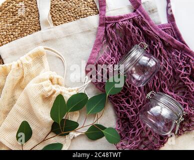 Baumwollbeutel, Netztasche mit wiederverwendbaren Glasgefäßen. Null-Abfall-Konzept. Umweltfreundlich. Flaches Lay Stockfoto