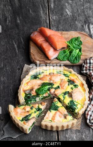 Lachs und Spinat Quiche auf rustikalem Holztisch Stockfoto