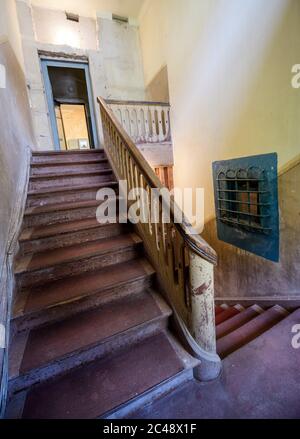 24. Juni 2020, Brandenburg, Potsdam: Die Treppe des ehemaligen Pfarrhauses und rechts das Balkenfenster einer Häftlingszelle im Ausstellungsbereich der Gedenkstätte und Begegnungsstätte Leistikowstraße. Bis zur Auflösung des KGB 1991 wurden Tausende von Männern und Frauen im Geheimdienstgefängnis im Zentrum der sowjetischen "Militärstadt Nr. 7" festgehalten. In der ersten Nachkriegszeit wurden auch Deutsche inhaftiert, später nur sowjetisches Militär und Zivilisten. Im ehemaligen Zentralgefängnis der sowjetischen Spionageabwehr, eine ständige Ausstellung von Fotografien, Original obj Stockfoto