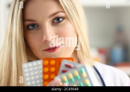 Schöne weibliche Arzt hält verschiedene Pillen und Kapseln Stockfoto