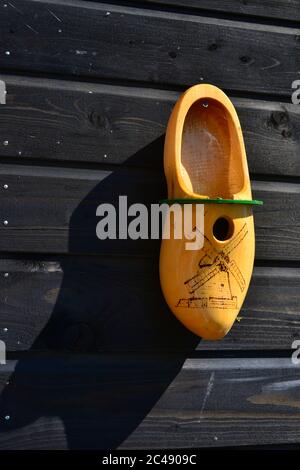 Alte bunte gelb bemalte Holzschuh als Nistkasten in einem Baum Stockfoto