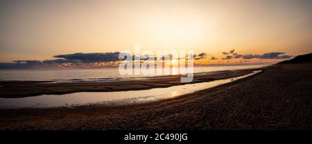 Panorama von schönen orange Abend Sonnenuntergang am Horizont, schöne Landschaft der ruhigen Seeseite in Sommerabend twhilights. Paradies für Sonnenuntergänge Stockfoto