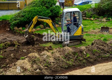 Ein Minibagger, der zur Vorbereitung eines Gartens für die Landschaftsgestaltung verwendet wird Stockfoto