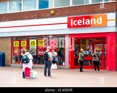 Eine Schlange von Menschen warten auf einen isländischen Supermarkt Sie sind 2 Meter auseinander als sichere Abstand während der Coronavirus oder Covi9 19 Pandemie Stockfoto