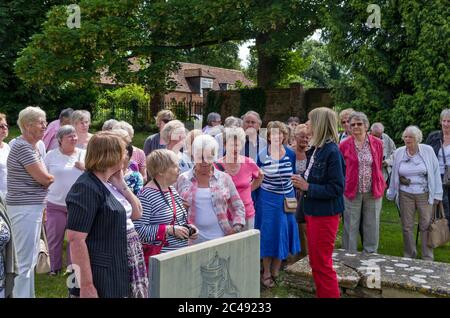 Eine Gruppe von Senioren, Mitglieder der U3A, mit einem Reiseleiter auf dem Kirchhof von St. Mary the Virgin, Ewelme, Oxfordshire, Großbritannien Stockfoto