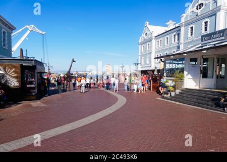 Kapstadt, Südafrika - 24. November 2019: Menschen beobachten Straßenkünstler an der Victoria & Alfred Waterfront an einem hellen warmen Tag Stockfoto