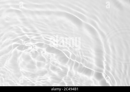 Nahaufnahme der entsättigte transparente klare ruhige Wasseroberfläche Textur mit Spritzern und Blasen. Trendy abstrakt Natur Hintergrund. Stockfoto