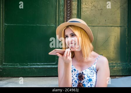 Junge schöne Mädchen hält Telefon und spricht aktivieren virtuelle digitale Sprachassistent auf Smartphone.Frau nutzt Smartphone Spracherkennung. Lebenszyll Stockfoto