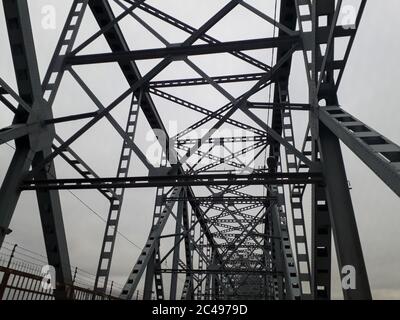 Metallkonstruktion der Eisenbahnbrücke mit dem aufsteigenden Mittelteil für die Durchfahrt von Schiffen. Blick von unten vom Fenster des Autos. Architektur, Designelemente Stockfoto