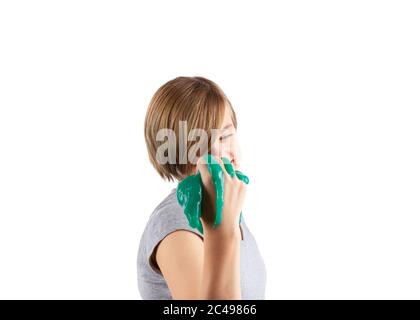 Grüner Schleim in junge Mädchen Hand gequetscht. Studio Shot isoliert auf weiß. Konzentriert auf das Mädchen. Stockfoto