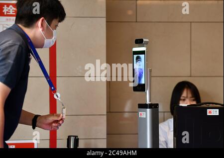 (200625) -- PEKING, 25. Juni 2020 (Xinhua) -- EIN Mann mit einer Maske benutzt eine Gesichtserkennungsvorrichtung, bevor er am 23. Juni 2020 in Tianjin im Norden Chinas beim vierten Weltnachrichtenkongress eintrat. UM MIT DEN XINHUA SCHLAGZEILEN VOM 25. JUNI 2020 zu GEHEN (Xinhua/Li Ran) Stockfoto