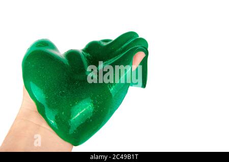 Flüssiges grünes Schleim Kind Spielzeug fließt auf der Hand. Isoliert auf weißem Hintergrund. Stockfoto