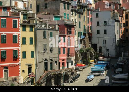 Riomaggiore, Cinque Terre, Ligurien. Ca. 2020. Farbige Häuser auf dem Riomaggiore Platz in der Cinque Terre. Boote sind auf dem Stadtplatz du geparkt Stockfoto