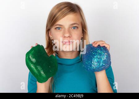 Junges Mädchen mit einem grünen und einem blauen Schleim Stockfoto