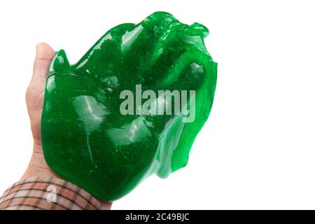 Hand hält einen transparenten grünen Schleim isoliert auf weiß Stockfoto