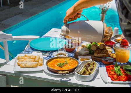 Konzept Promotion Frühstück im Hotel, leckere Ei Benedikt, türkische und französische Frühstück, Tee und Orangensaft. In der Nähe des Pools Stockfoto