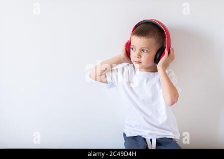 Glücklich lächelndes Kind genießt Musik in Kopfhörern hören Stockfoto