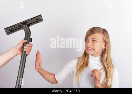 Hand hält einen Staubsauger Bodenwerkzeug, aber das Mädchen verweigert Hausarbeit. Stockfoto