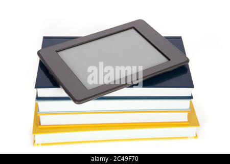EBook Reader mit leerem Bildschirm auf dem Stapel von Papierbüchern. Isoliert auf Weiß. Stockfoto