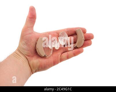 Hand des Mannes, der ein Paar BTE-Hörgeräte mit Ohrmugelform hält Stockfoto