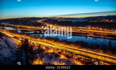 Blick auf die Barrandov-Brücke über die Moldau in Branik, Prag, Tschechische Republik. Beleuchtete Straßen in kalten Winterabend. Stockfoto