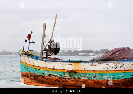 Hammamet, Tunesien- 07. Februar 2009: Tunesische Fischerboote am Strand in ihren traditionellen Farben. Stockfoto