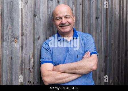Glücklicher älterer Mann, der draußen lächelt. Stockfoto
