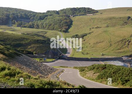 Ein langer Blick auf die alten Dunraven Burgruinen und ummauerten Garten auf dem fernen Hügel, ohne Menschen wegen der Absperrung an einem schönen Tag. Stockfoto