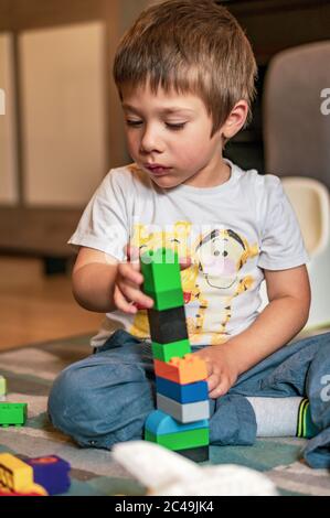 POSEN, POLEN - 30. Mai 2020: Kleiner polnischer Kaukasischer zwei Jahre alter Junge, der auf einem Boden sitzt und mit Lego Duplo spielt. Stockfoto