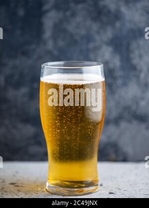 Ein Glas helles Bier auf dunklem Grund Stockfoto