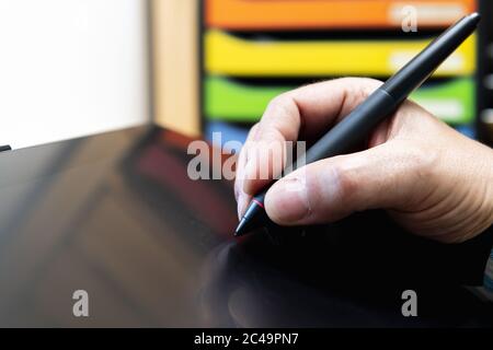 Nahaufnahme einer Hand mit einer Stiftzeichnung auf einem grafischen Tablett, Grafikdesign-Konzept Stockfoto
