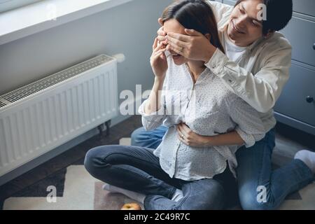 Aufgeregt schwangere Frau immer Überraschung von ihrem geliebten Mann Stockfoto
