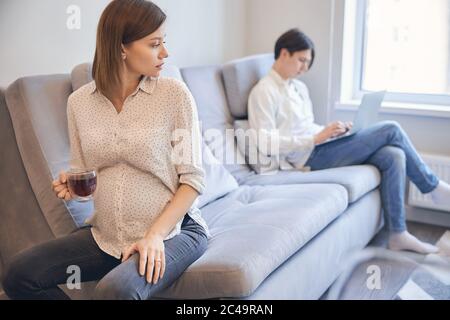 Paar sitzt auf verschiedenen Seiten des Sofas zu Hause Stockfoto