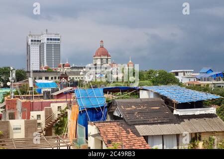 Dunkle Monsunwolken schweben über dem Taj Mahal Palace Hotel in Mumbai, Indien, und ragen über den chaotischen Dächern der umliegenden Colaba-Gegend der Stadt Stockfoto