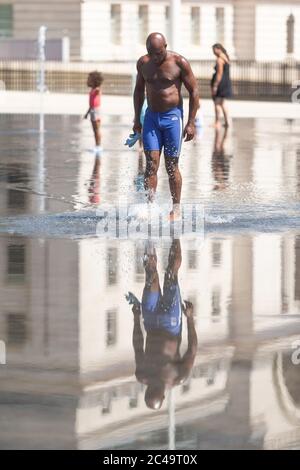 Schwarzer Mann beim Spaziergang im seichten Wasser, Centenary Square, Birmingham Großbritannien Stockfoto
