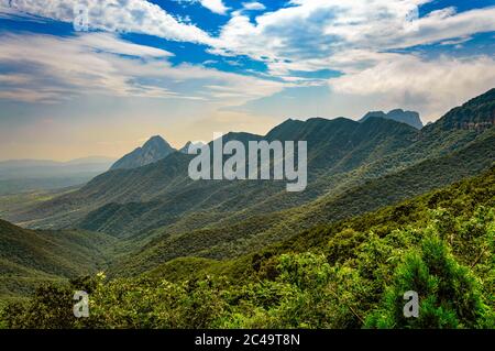 Aufnahme der atemberaubenden Berge, die von Wäldern bedeckt sind, die unter dem Hotel glitzern Der bewölkte Himmel Stockfoto
