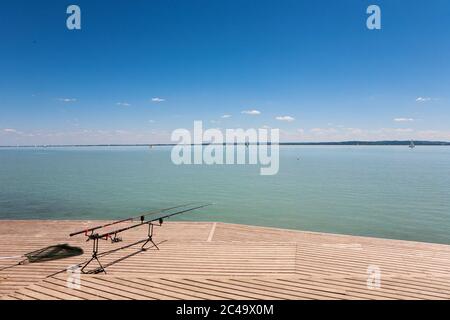 Angelruten auf Holzsteg am Plattensee, Ungarn Stockfoto