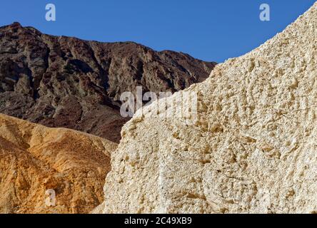 3 Steinfarben mit dem Blau des Himmels sind ein abstraktes Foto. Beim Spaziergang durch den Golden Canyon im Death Valley war ich fasziniert von den verschiedenen Felsformationen und deren Farben. Stockfoto