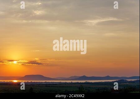 Sonnenuntergang über dem Plattensee und Badacsony Berg in Ungarn Stockfoto
