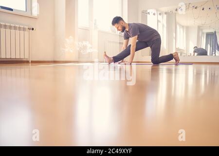 Bärtiger Mann, der Übung im Yoga-Studio macht Stockfoto